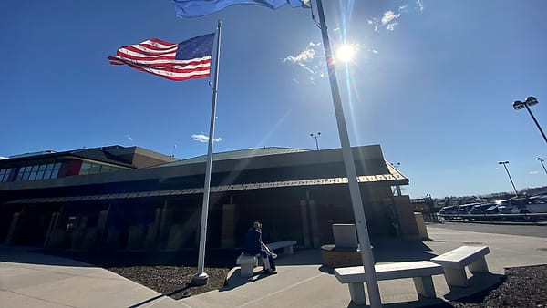 The flags of the United States and Westchester County flying beside the terminal at Westchester County Airport