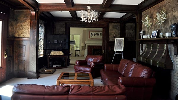 The living room of Lochkelden in the Windermere neighborhood of Seattle, Washington, with its fireplace and panelling