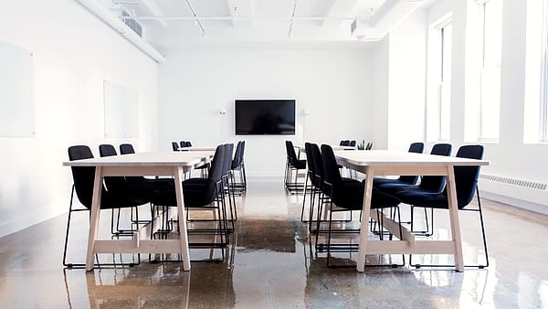 Tables and chairs arranged in an empty boardroom on Chambers Street in New York, lit from the windows