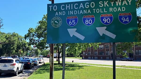 A large overhead highway sign in Chicago directing drivers to the Chicago Skyway and the Indiana Toll Road