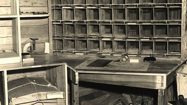 A mail room with pigeonholes and sorting shelves at Skyland, with letters standing in the slots