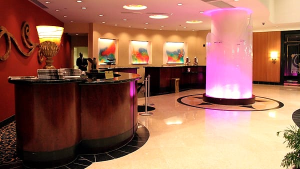The front desk of a hotel in New Orleans, Louisiana, with the counter empty and the lobby beyond