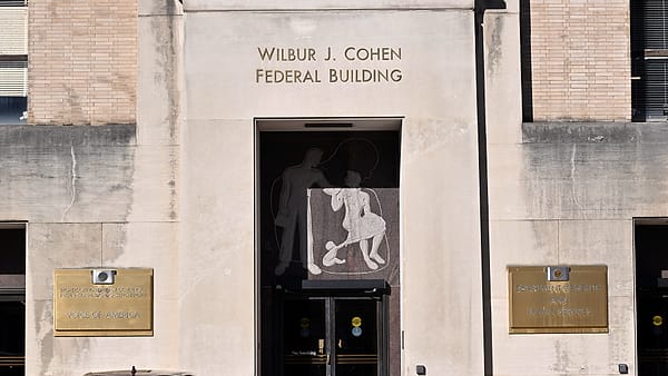 The C Street entrance to the Wilbur J. Cohen Federal Building in Washington, D.C., with signage beside the door