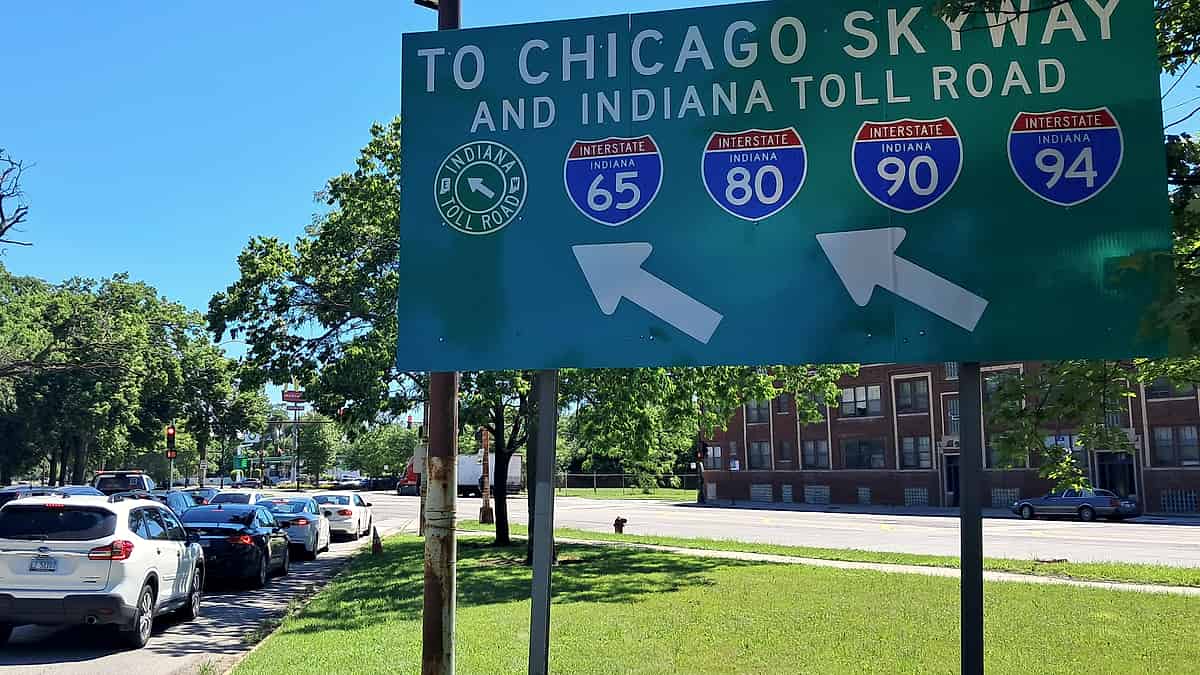 A large overhead highway sign in Chicago directing drivers to the Chicago Skyway and the Indiana Toll Road
